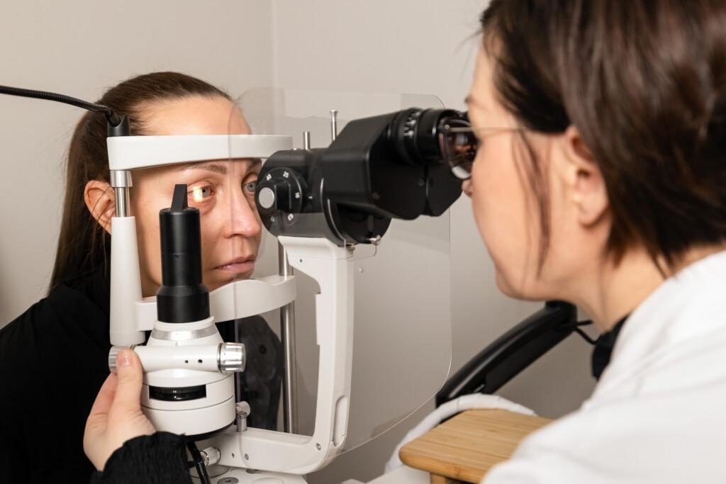 Optikko tutkii asiakkaan silmiä mikroskoopilla